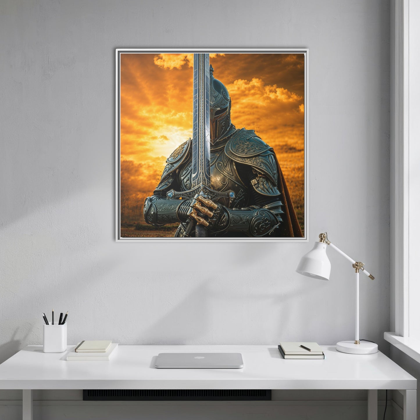 White framed Chapter 1 canvas of a medieval knight with sword under a golden sky, styled above a minimalist white desk in a bright office.