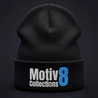 Studio close-up of Motiv8 Collections black cuffed beanie on dark background, blue 8 and white logo embroidery centered and clearly visible.